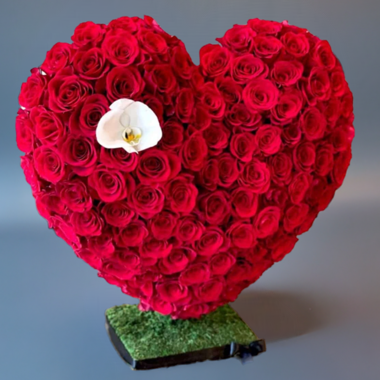 Heart-shaped arrangement of red roses  on a green base, handcrafted by Takkoush Flowers in Beirut, Lebanon.