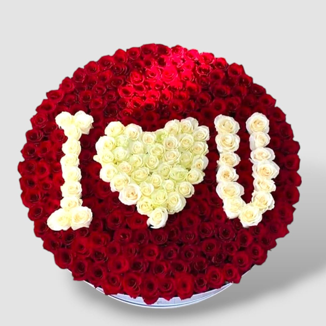 Round arrangement of red roses with white roses forming “I ❤️ U,” handcrafted by Takkoush Flowers in Beirut, Lebanon.