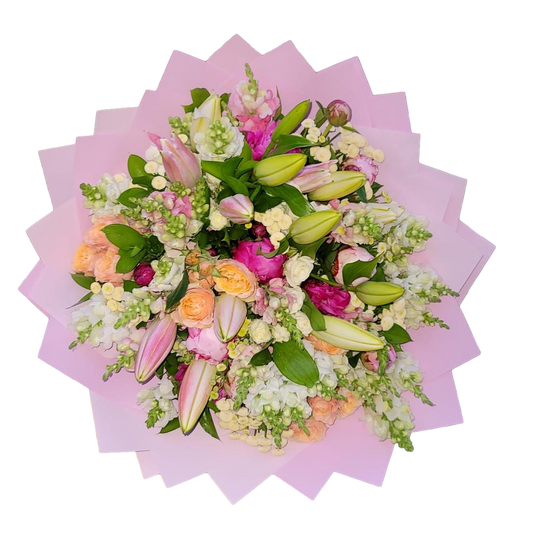 A mixed flower bouquet with a predominance of pink roses and lilies, wrapped in pink paper.