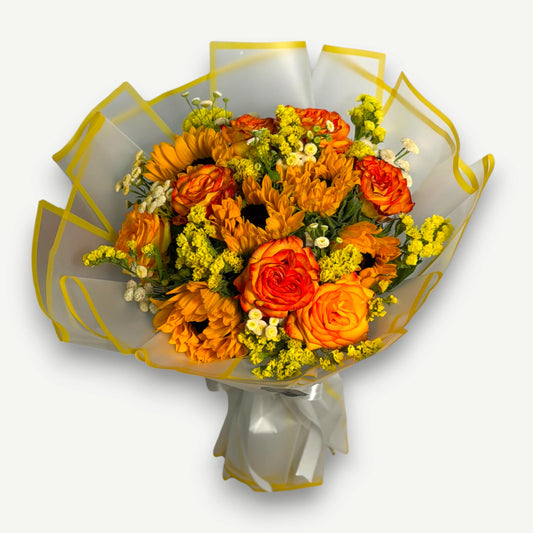 Bouquet of orange sunflowers and orange roses with yellow statice and white chamomile daisies, wrapped in white and yellow paper