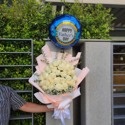 A beautiful bouquet of 36 white roses with a helium balloon saying "Happy father's day"