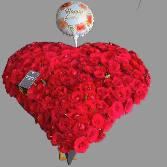 Luxurious heart-shaped red roses arrangement with balloon. Handcrafted by Takkoush Flowers. Same-day delivery in Beirut, Lebanon. Order now.