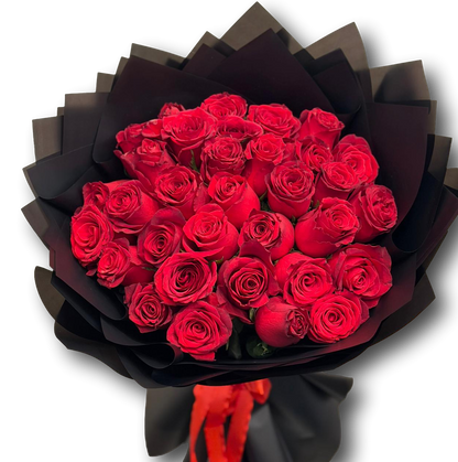 Bouquet of red roses wrapped in black paper on a white background