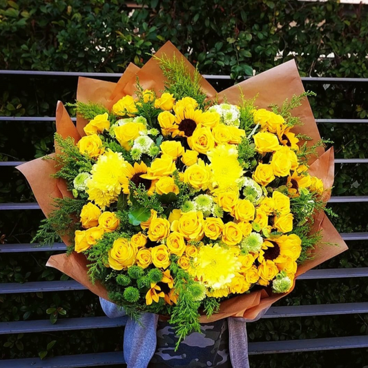 Brighten up your day with our vibrant mixed flower bouquet! Featuring a stunning combination of yellow roses, sunflowers, and green and yellow chrysanthemums, this bouquet is sure to make a statement. The bouquet also comes with extensions and other accessories to make it even more special. Whether you're looking to brighten up your own space or surprise someone special, our mixed flower bouquet is the perfect choice. Order now and enjoy the beauty of fresh flowers delivered right to your door!